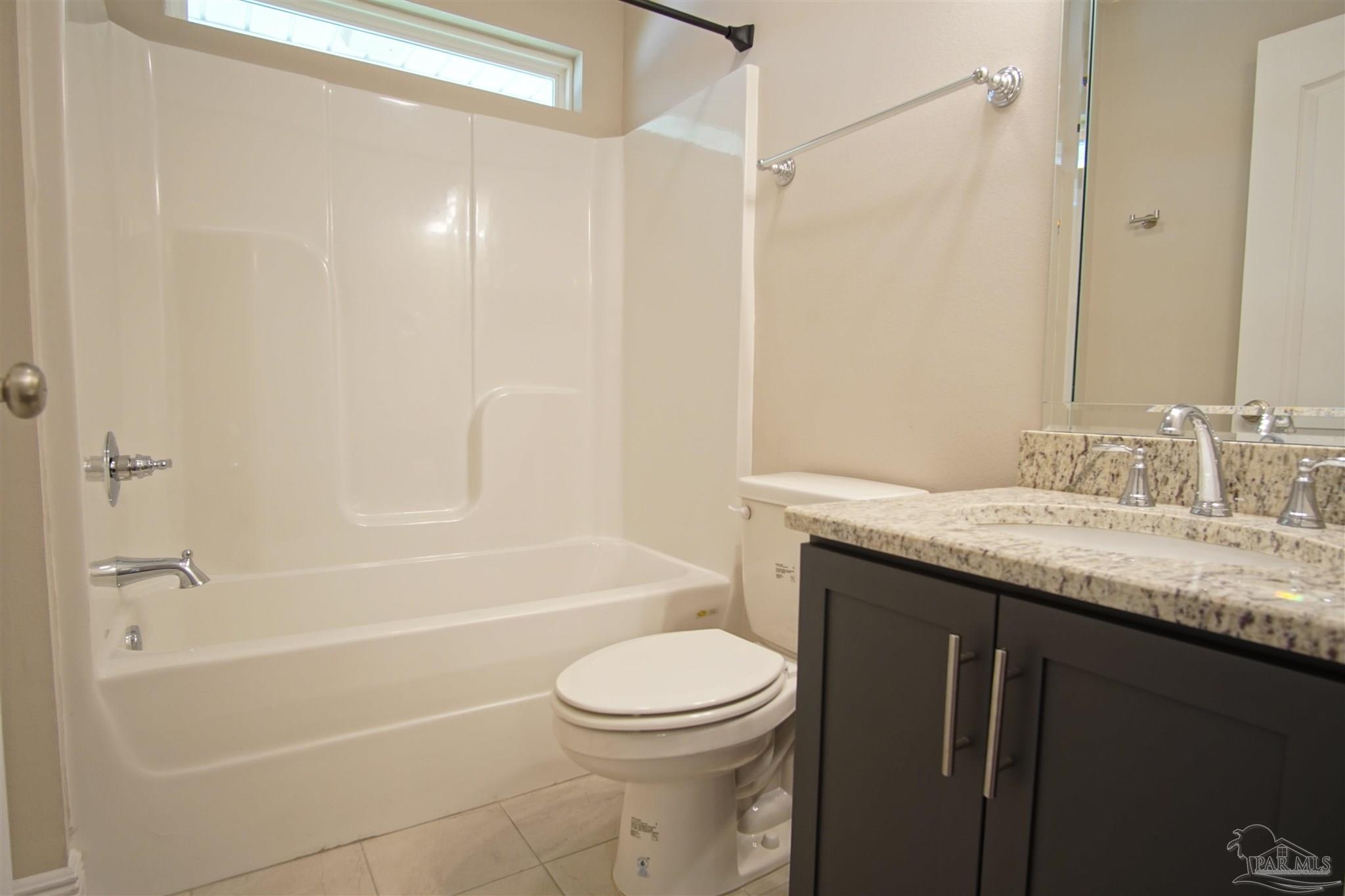 5734 Dunridge Drive Pace, FL 32571 - Photo 19 of 26 a bathroom with a granite countertop sink a toilet and shower