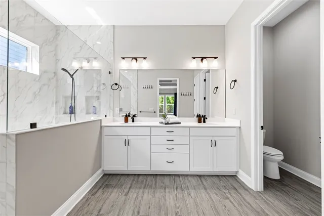 a bathroom with a granite countertop sink toilet and shower