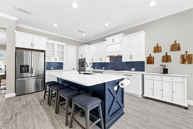 a kitchen with white cabinets and appliances