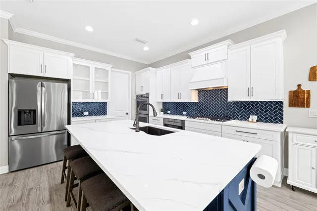 a kitchen with stainless steel appliances a refrigerator and a stove top oven