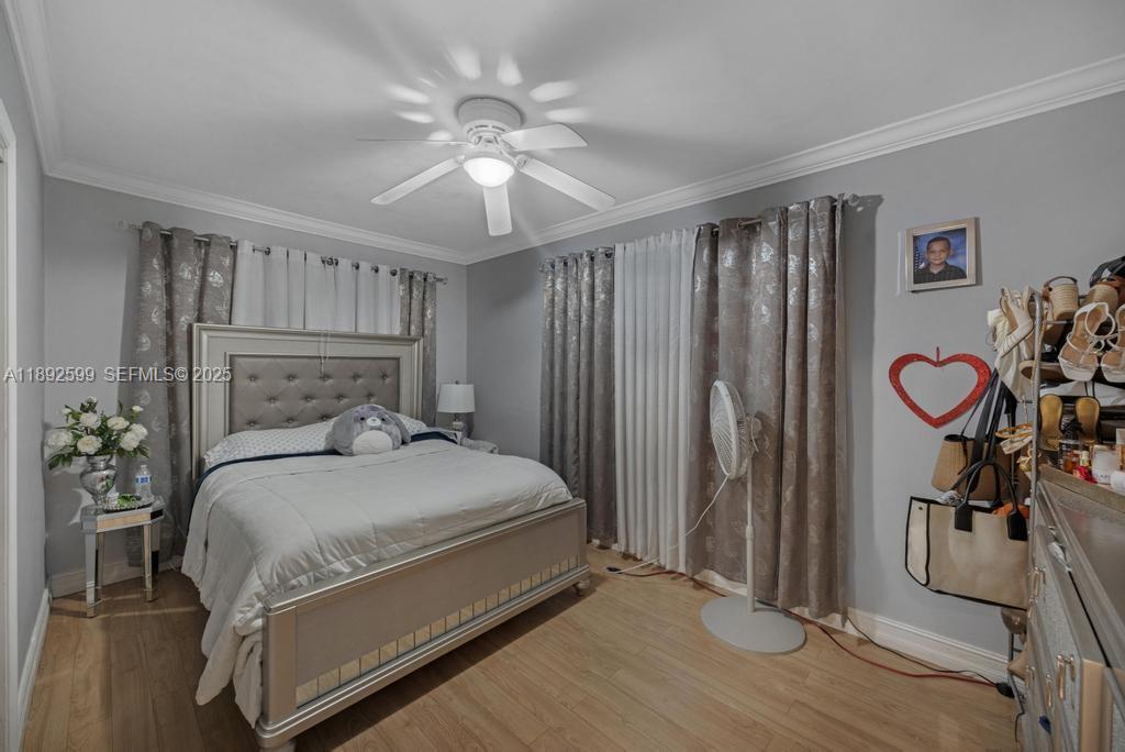 155 West 60th Street Hialeah, FL 33012 - Photo 19 of 29 a bedroom with a bed and a chandelier