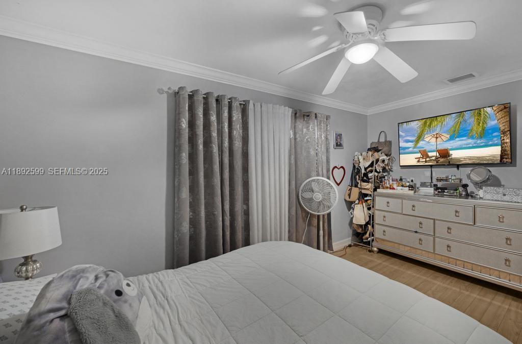 155 West 60th Street Hialeah, FL 33012 - Photo 22 of 29 a bedroom with a bed and a flat tv screen on dresser