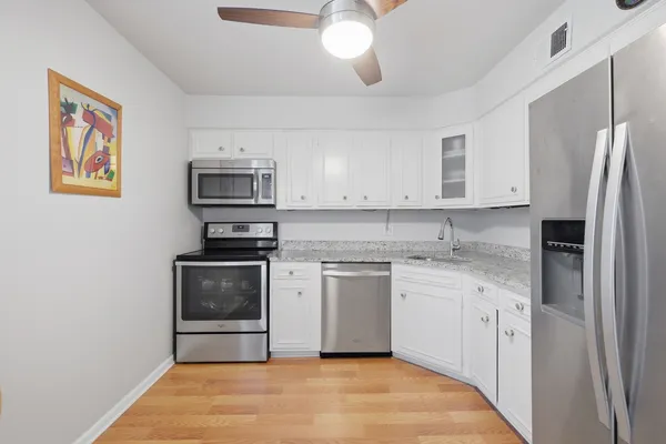 a kitchen with stainless steel appliances granite countertop a stove a sink a microwave a dining table and chairs