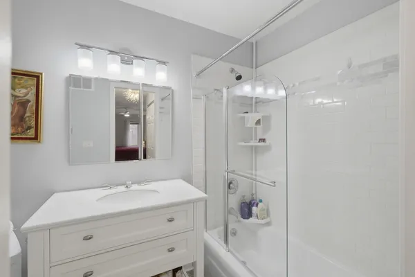 a bathroom with a granite countertop sink mirror vanity and toilet