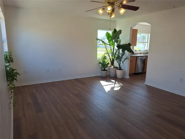 a kitchen with cabinets wooden floor and stainless steel appliances