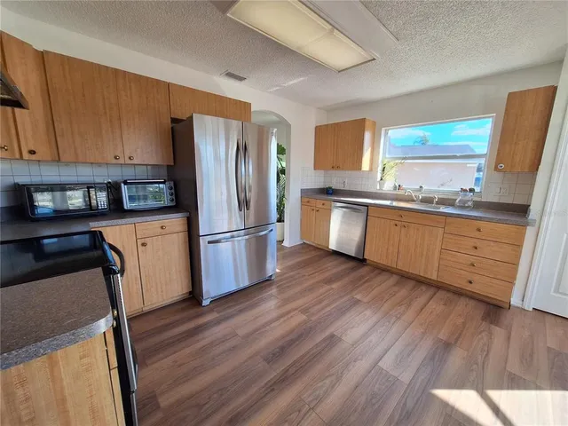 a view of an empty room with a window and a ceiling fan