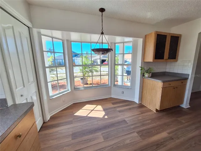 a view of a hallway with wooden floor and plant