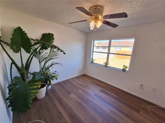 a view of a room with wooden floor and white walls
