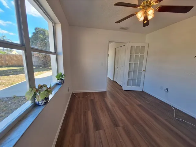a view of a hallway with wooden floor and a potted plant