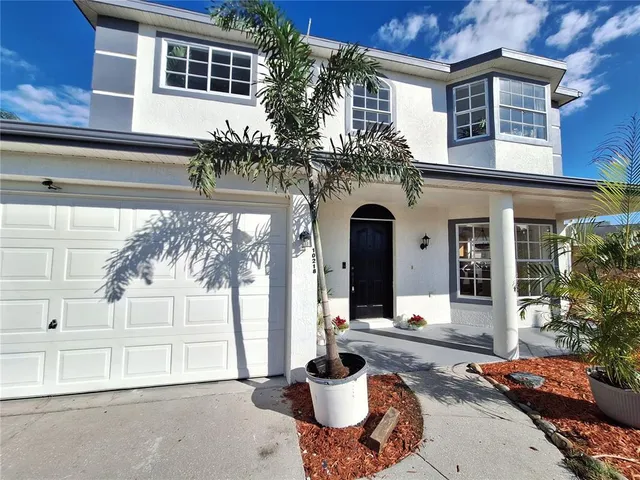 an empty room with wooden floor and a ceiling fan