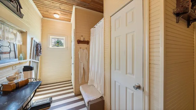 a view of a hallway with wooden floor and furniture