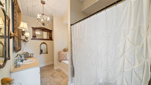 a bathroom with a sink a mirror and a shower curtain