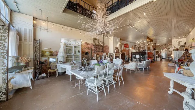a large room with lots of tables a chandelier and couches