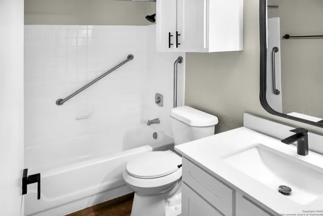 a bathroom with a sink a toilet and shower