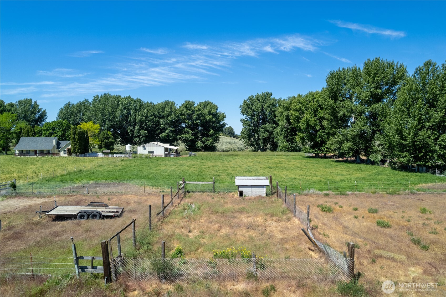 10898 Northeast 5.2 Road Moses Lake, WA 98837 - Photo 38 of 40 a view of a lake with lawn chairs and wooden fence