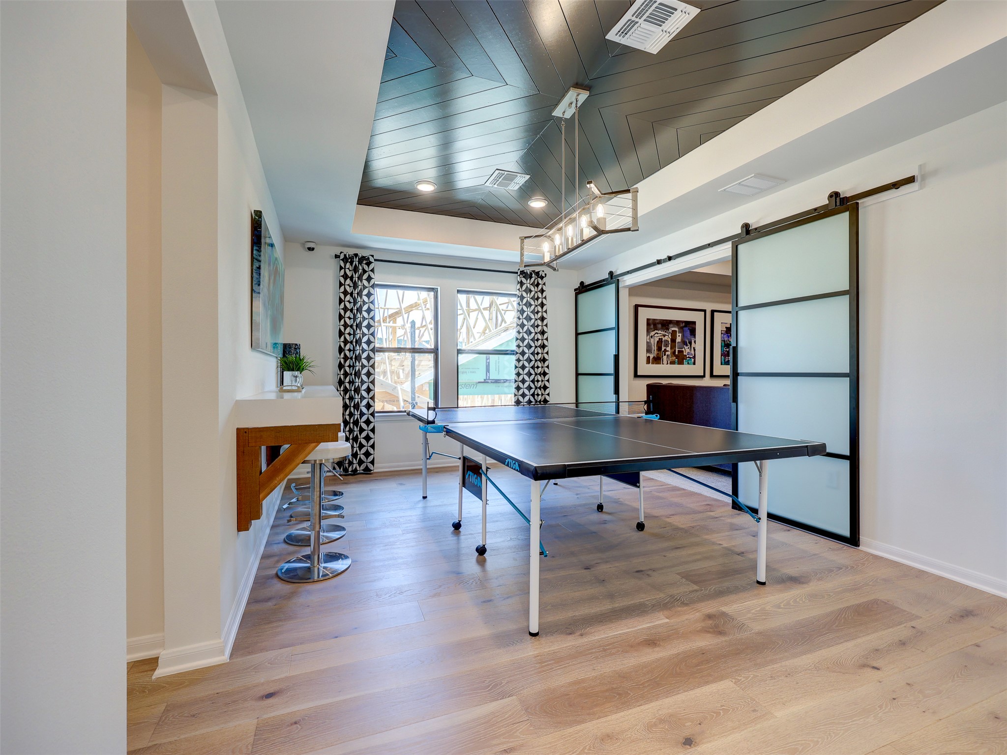 6220 Bower Well Road Austin, TX 78738 - Photo 28 of 28 A vibrant game room offers an exciting space for recreation with wide plank flooring and a distinctive ceiling design.