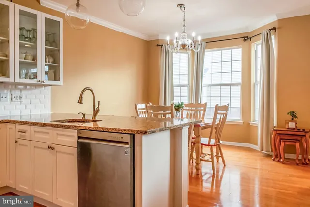 a kitchen with stainless steel appliances a table and chairs in it