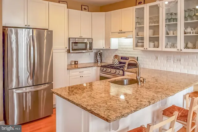 a kitchen with stainless steel appliances granite countertop a refrigerator sink and cabinets