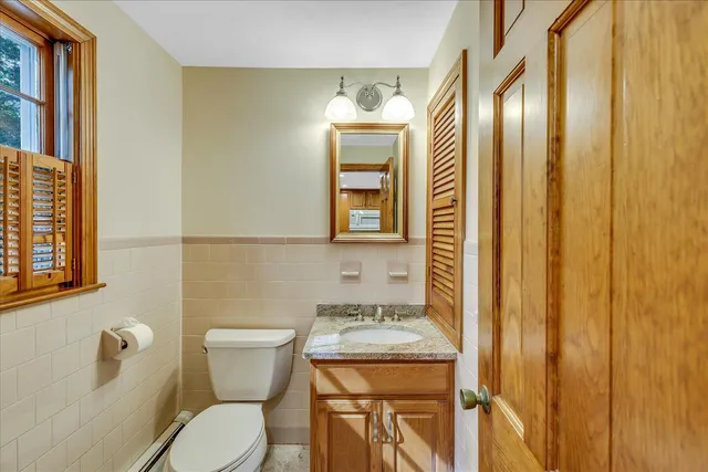 an empty room with wooden floor closet and windows