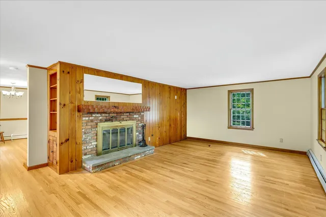 a view of an empty room with a fireplace and a window