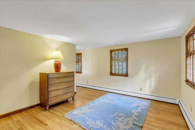a view of a bedroom with wooden floor and chandelier