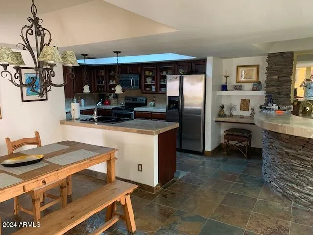 a kitchen with stainless steel appliances granite countertop a sink a stove and a refrigerator