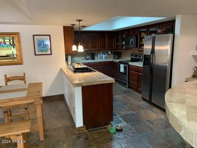 a kitchen with stainless steel appliances granite countertop a refrigerator a stove and a sink