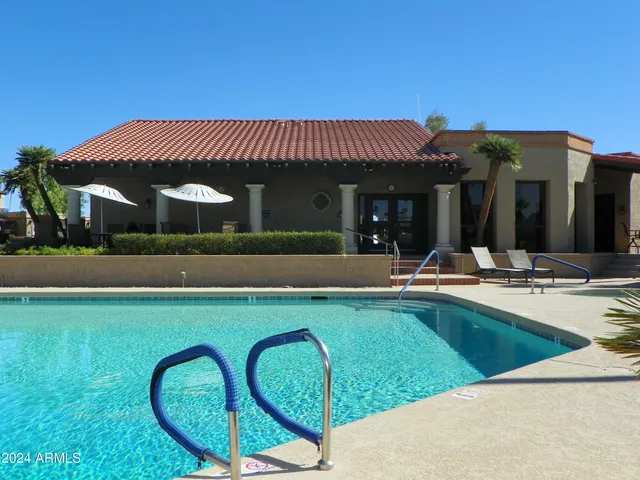 a view of a house with swimming pool and a table and chairs