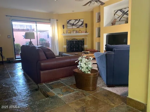 a living room with furniture a fireplace and a floor to ceiling window