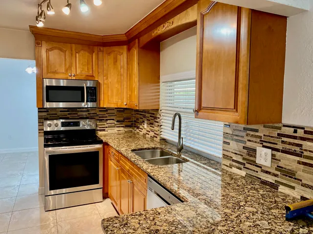 a kitchen with granite countertop a stove and a sink