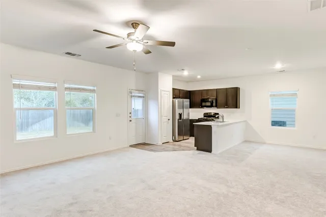 an empty room with a ceiling fan and window
