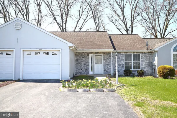 a front view of a house with a garden and yard