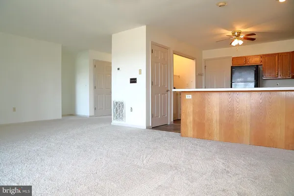 a view of a livingroom with wooden floor and a ceiling fan