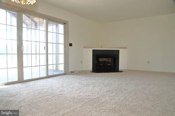 an empty room with a fireplace and window