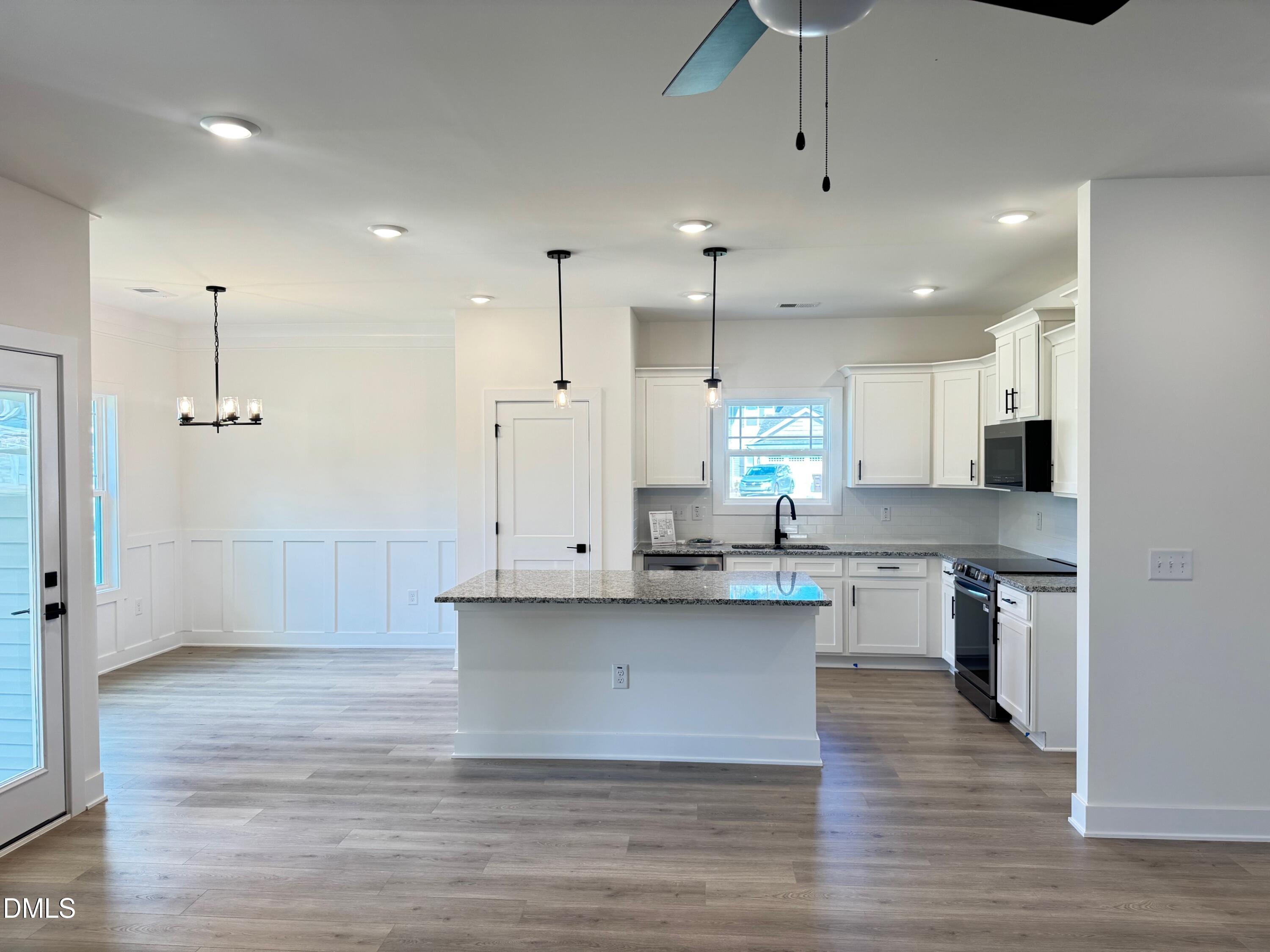20 Streamline Court Lillington, NC 27546 - Photo 15 of 46 a large kitchen with stainless steel appliances kitchen island granite countertop a large counter top a sink cabinets and a wooden floor