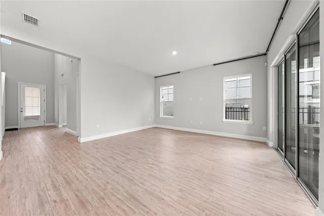 a large kitchen with stainless steel appliances a large counter top and a refrigerator