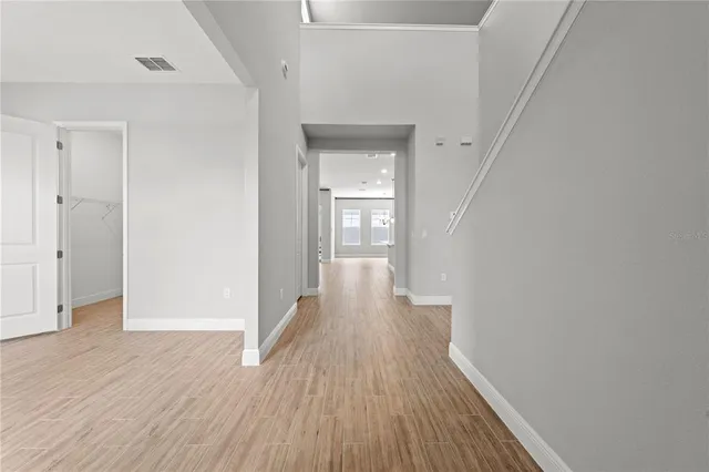 a view of an empty room with wooden floor & closet