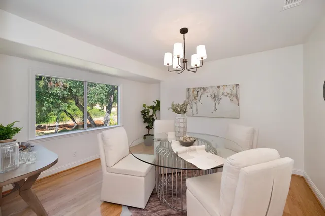 a living room with furniture floor to ceiling window and a flat screen tv