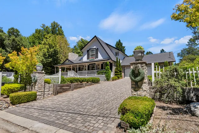 a front view of a house with a yard and potted plants