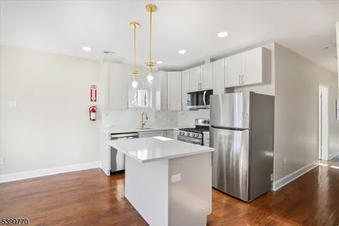 a kitchen with stainless steel appliances a refrigerator sink and microwave