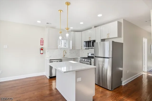 a kitchen with stainless steel appliances a refrigerator sink and microwave