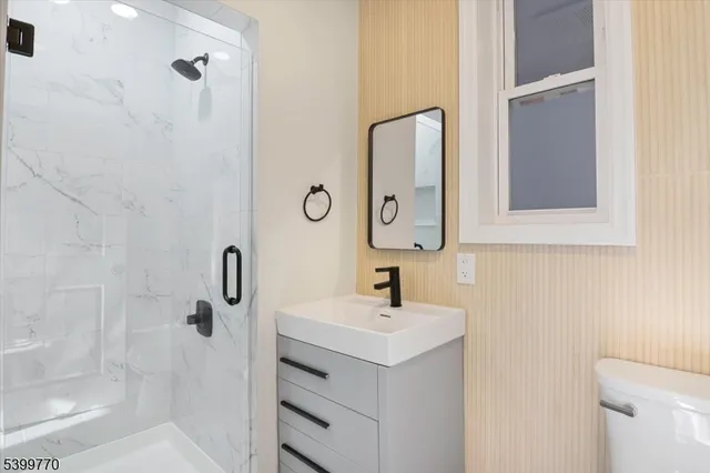 a bathroom with a sink a toilet and shower