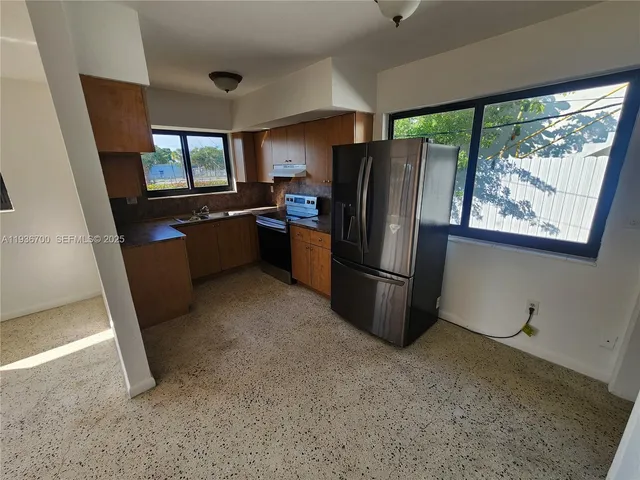 a kitchen with refrigerator and window