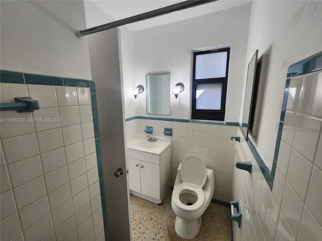 a bathroom with a sink and mirror with toilet