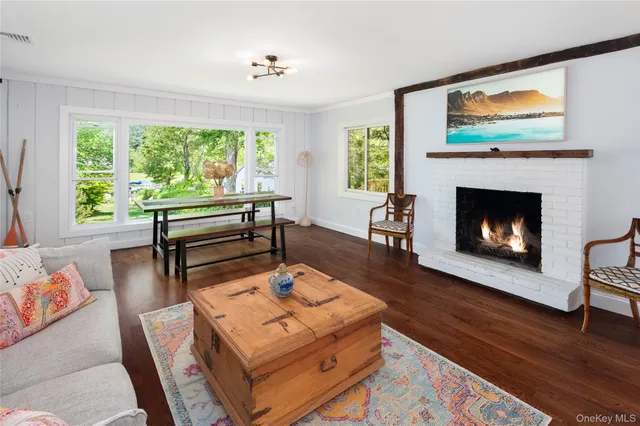 a living room with furniture a fireplace and a large window