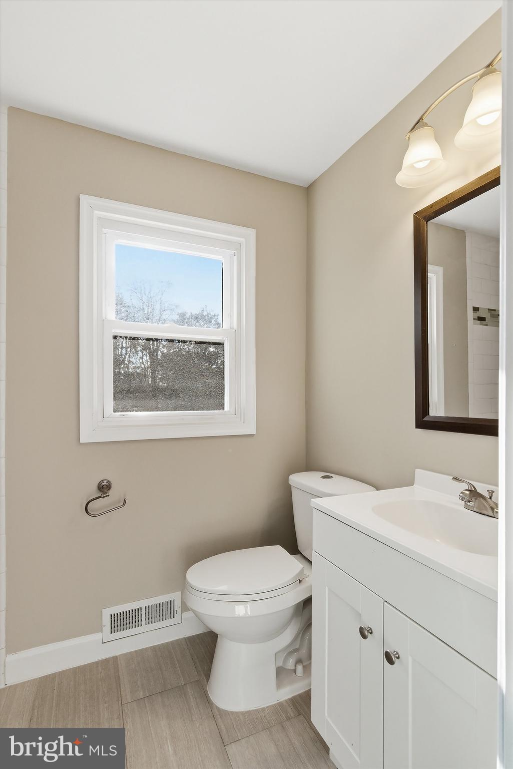 183 Jordan Road Somers Point, NJ 08244 - Photo 29 of 40 a bathroom with a toilet a sink a mirror and a window