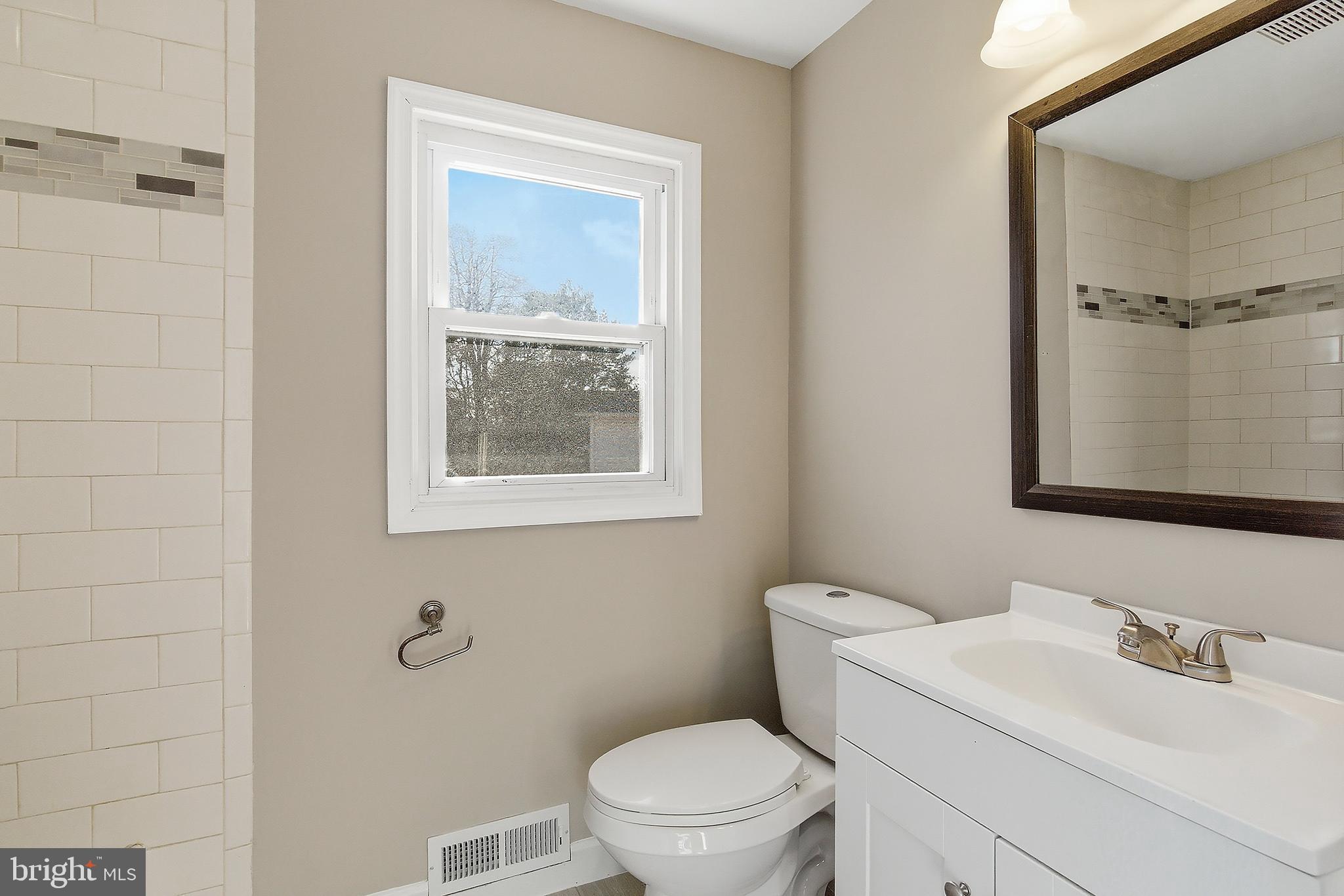 183 Jordan Road Somers Point, NJ 08244 - Photo 31 of 40 a bathroom with a toilet sink vanity and mirror