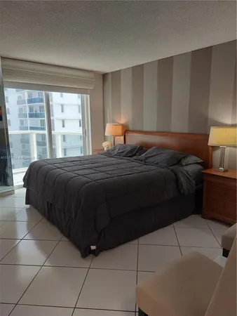 a bedroom with a bed window and table lamp