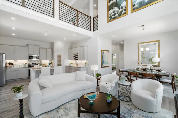 a living room with furniture kitchen view and a large window