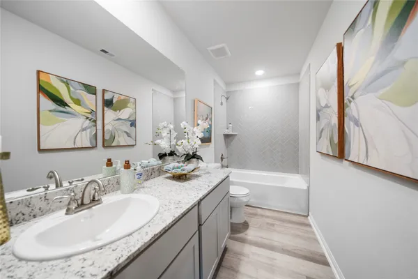 a bathroom with a bathtub double vanity sink and a mirror